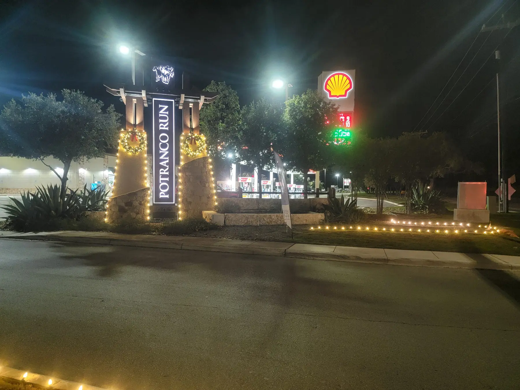 Commercial driveway and business entrance outlined with warm white holiday lights