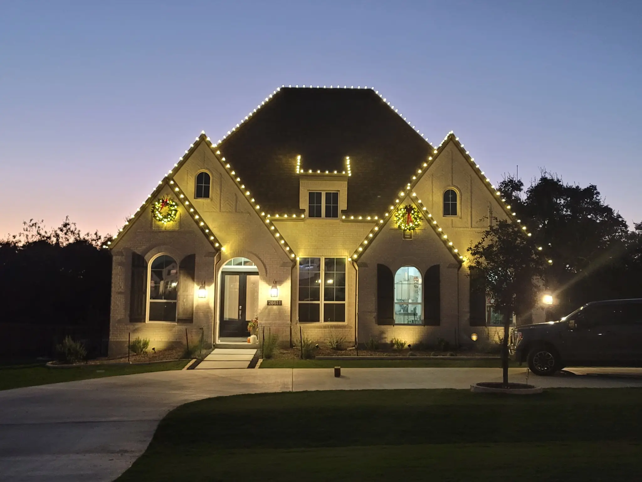Light It Up Holiday warm white roofline and wreath installation on a San Antonio-area home
