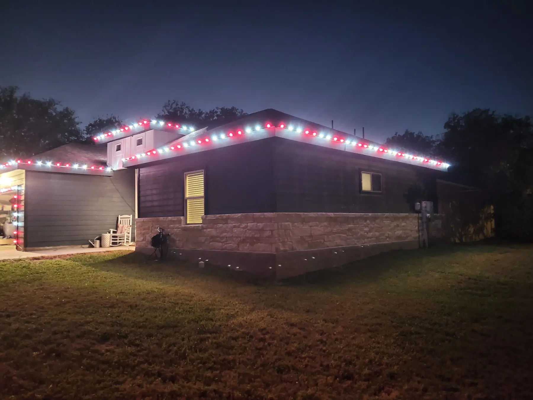 Single-story home outlined with alternating red and white holiday lights
